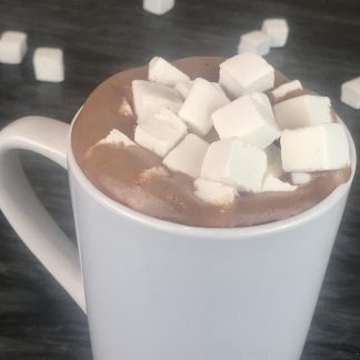A mug of hot cocoa topped with homemade mini vanilla marshmallows setting on a black marble board