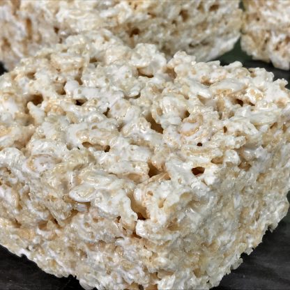 This photo shows a closeup of a Marshmallow Crispie with other Crispies in the background.