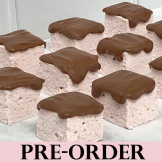 A closeup photo showing strawberry marshmallows topped with Belgian milk chocolate. The marshmallows are on a light gray marble board. The word 'PRE-ORDER' is across the bottom of the photo.