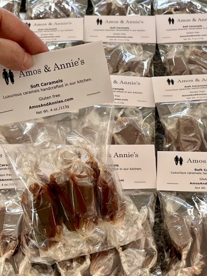 A hand holds a package of soft caramels